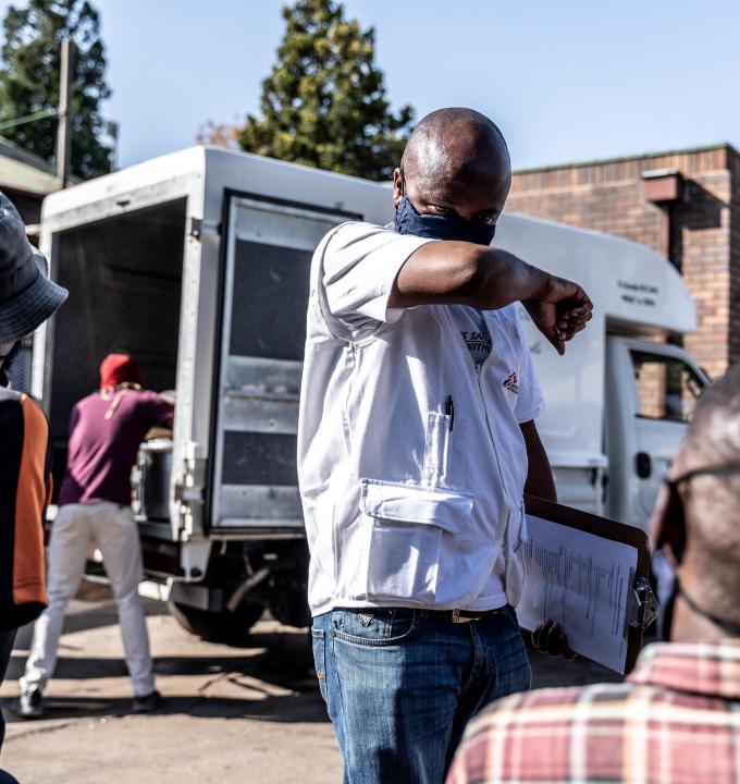 An MSF Health Promoter speaks with people about how to keep safe during the COVID-19 pandemic.