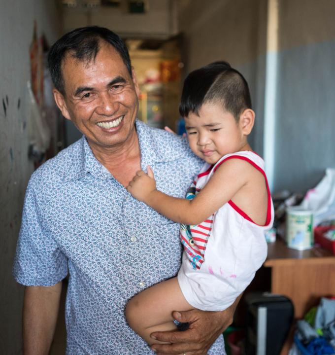 Din Savorn, 50, with his son during lunchtime at their apartment in Phnom Penh, Cambodia, 20, April 2017.