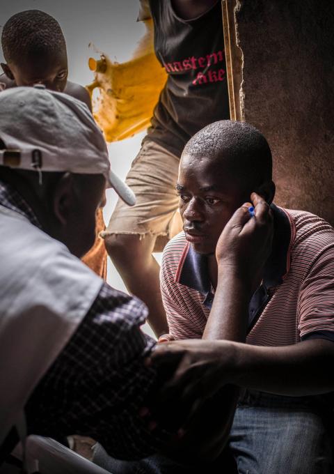 MSF provides ambulatory and door to door testing for HIV. This man was born with aids, he led a normal life thanks to his medicine until he got to the university. People made fun of him for taking pills, so he stopped taking them. He his now deaf and blind. His uncle communicates with him by writting on his arm.
