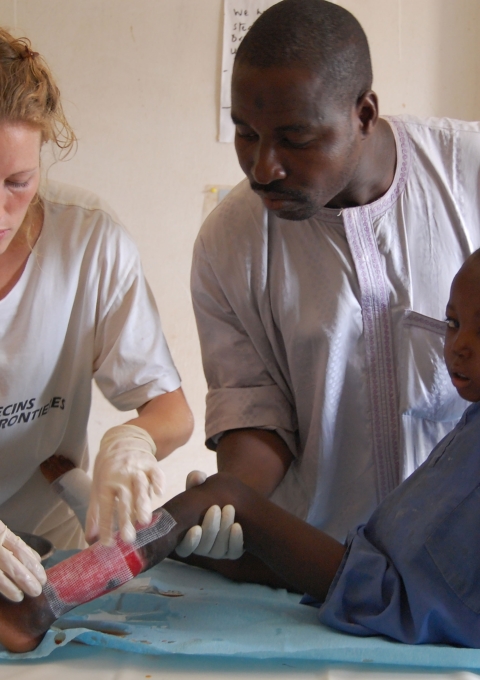 Paediatric nurse Claire Hudson and MSF nurse Mutola dress 7 year old Kabiru’s wound from a suspected snake bite. Goronyo, Nigeria.