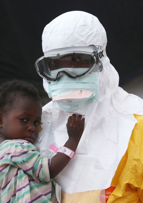 A Doctors Without Borders (MSF), health worker in protective clothing holds a child suspected of having Ebola in the MSF treatment center on October 5, 2014 in Paynesville, Liberia. The girl and her mother, showing symptoms of the deadly disease, were awaiting test results for the virus. The Ebola epidemic has killed more than 3,400 people in West Africa, according to the World Health Organization.