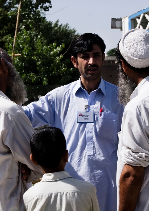 Nurse Nasir answering questions after a health promotion about Hepatitis B and C in the male waiting area. Dargai, Pakistan.
