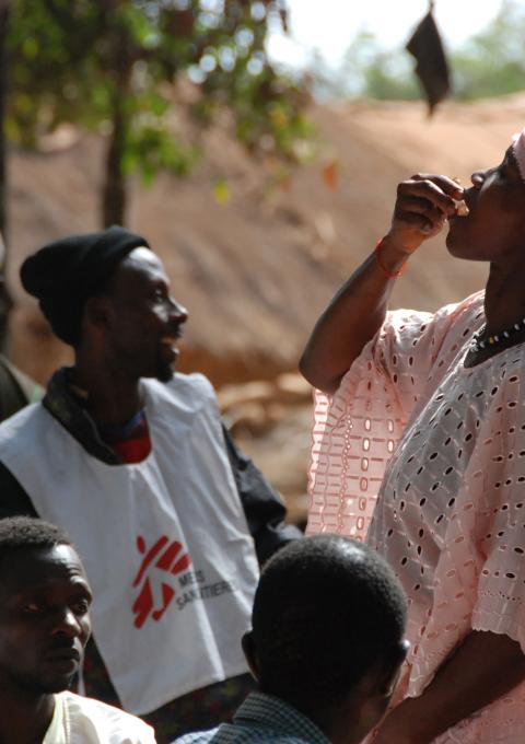 Woman drinking the first dose of the first oral vaccine against cholera in Africa during an epidemic, Guinea, Tougnifili/Mankountan, 2012