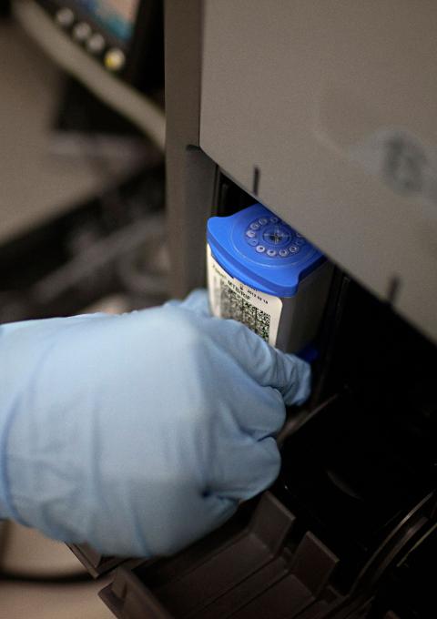 Medical officer Neisha Mohess, scans a sample of sputum for loading into an automated molecular TB diagnostic machine called GeneXpert.