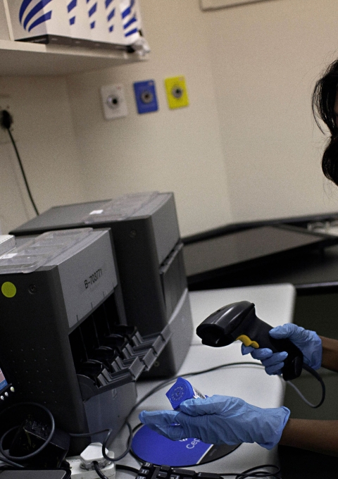 Medical officer, Neisha Mohess scans a sample of sputum for loading into the GeneXpert, an automated molecular TB diagnostic test machine.