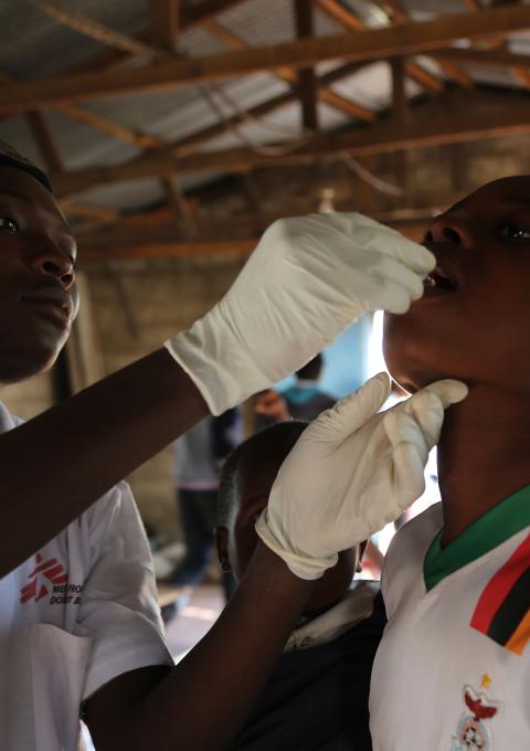 A member of the MSF vaccination team provides a single dose of oral cholera vaccine to a boy at True Vine Church, one of the 15 sites used by MSF in the district of Kanyama during a massive vaccination campaign in Lusaka