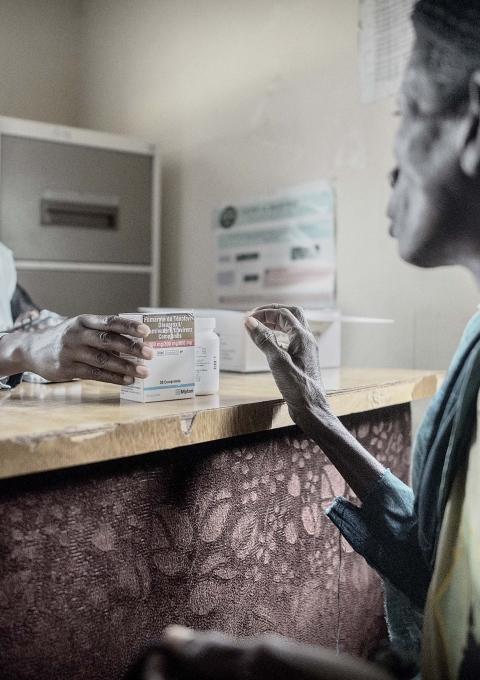 MSF staff nurse mentor Ndumezi Shaba (left) hands a prescription to Selena Bishop from Ng'ombe village at Sorgin Health Centre, Nsanje Malawi, 2017..