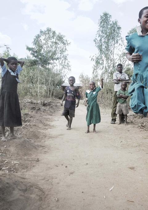 Gloria Chipasula, 11 years old MSF's HIV and TB positive patient stands in in the middle of the road (green dressed) as she plays with her young relatives and village's friends.