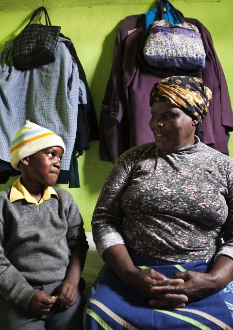 Thenjiwe Madzinga, 66, sits on with her grandson Thina Gxotelwa in the small room they share in a shack in Cape Town's Khayelitsha township, February 23, 2010. Madzinga cares for her five grandchildren, including four who were orphaned when Madzinga's own daughter died from AIDS in 2002. Some 5.5 million people live with HIV/AIDS in South Africa - more than in any other country - placing a heavy burden on a society still struggling with the legacy of Apartheid. 
