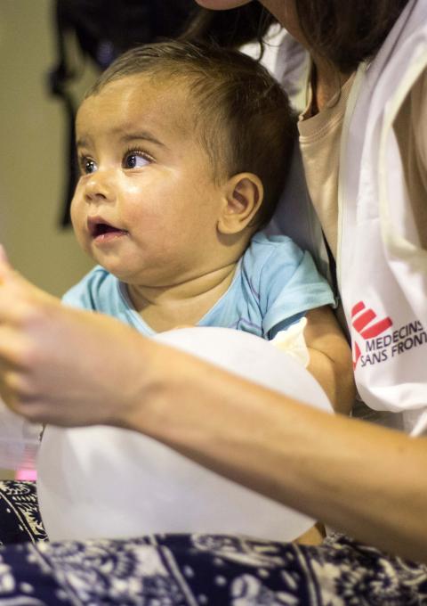 MSF staff taking care of a child after he has been vaccinated. Photograph by Pierre-Yves Bernard