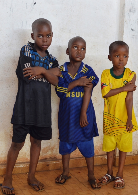 Three young boys at a vaccine clinic in Guinea
