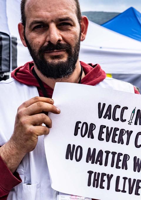 •	MSF logistician, Athanasios Papadopoulos holding a sign advocating for broader use of the pneumonia vaccine at a lower price