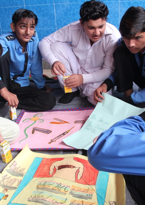 A local youth peer group discuss final changes to their posters for the world hepatitis day celebrations.