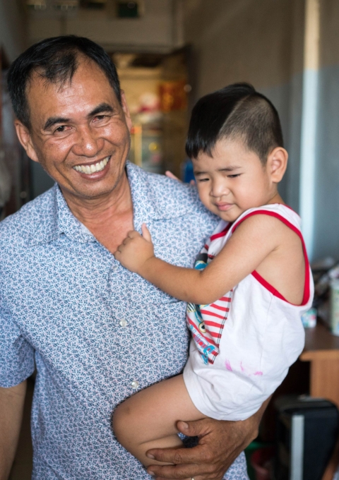 Din Savorn, 50, with his son during lunchtime at their apartment in Phnom Penh, Cambodia, 20, April 2017.