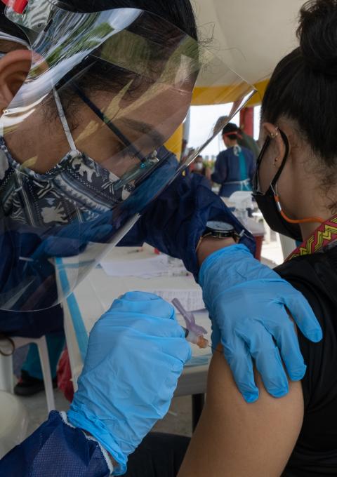 A health worker with Puerto Rico Salud vaccinates a resident of Humacao on the eastern coast of Puerto Rico, at a public vaccination event.