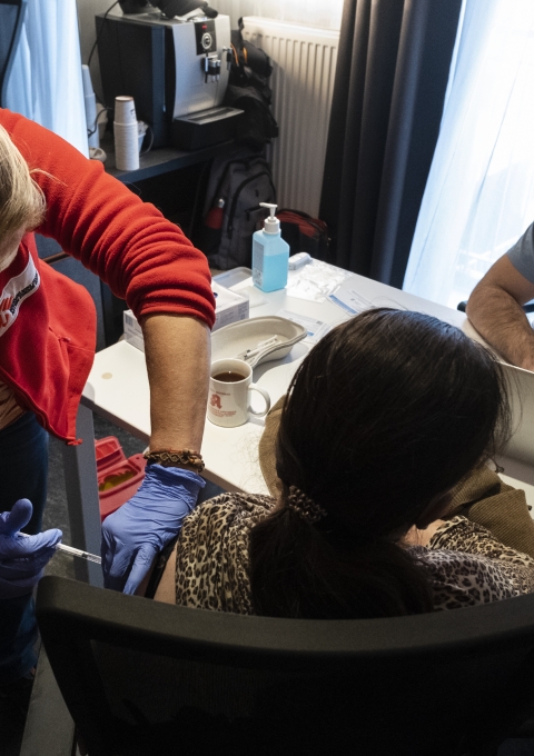 An MSF staff administrates the vaccine to a homeless person.