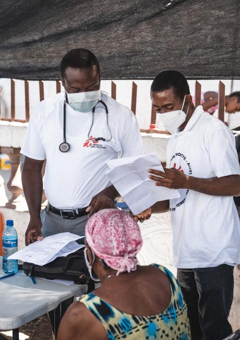 MSF Medical Doctor, Mayard Mitial (R), and MSF Medical Doctor, Fenelon Jean (L), consult with a patient in St Yves.