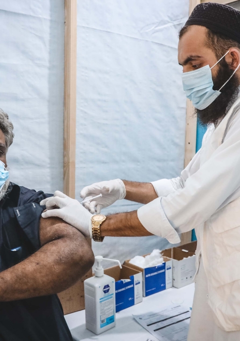An MSF nurse administering the COVID-19 vaccine to Muhammad Sarwar.