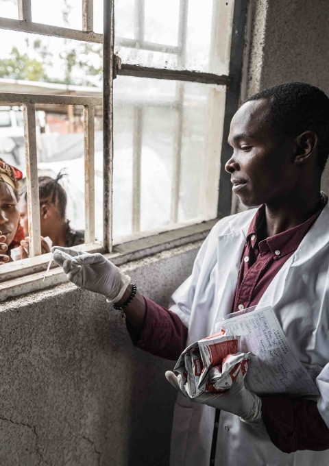 MSF’s Samuel Mugabo provides nutritional therapeutic food and medications to Foibe Bonane, a displaced mother whose child is battling malnutrition and measles, in North Kivu, Democratic Republic of the Congo.