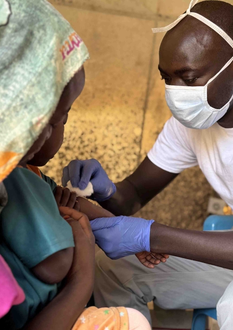 Salah Aldeen - nurse – places an intravenous line to Marwa, 3 years. Marwa was admitted the day before, as she was presenting common symptoms of measles. Amir, her big brother, who lies in the next tent, was admitted 5 days earlier for the same reason.