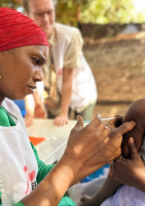 Diaka Kaba, a member of the MSF team, administers a diphtheria vaccine to a child in the Hèrèmakonön neighbourhood of Siguiri, Guinea as part of a vaccination campaign. 2026. © Mohamed Mara, MSF.
