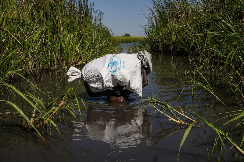 A young boy struggles through the swamps in Unity State, South Sudan. 