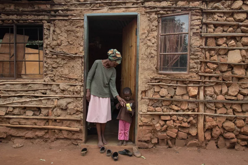 Winile stands outside her house in the Manzini region of Swaziland
