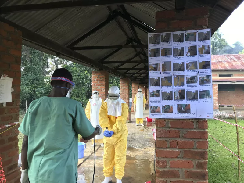 Desinfection of staff dressed in full PPE in the ETC (Ebola Treatment Centre) in Bikoro, DRC 2018. Photograph by Louise Annaud