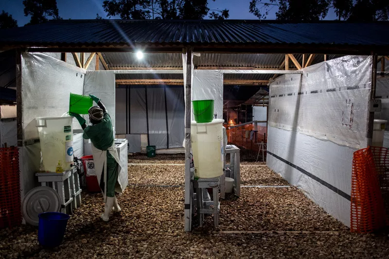 A health worker pours fresh chlorinated water into containers inside a MSF supported Ebola Treatment Centre (ETC) on November 04, 2018 in Butembo.