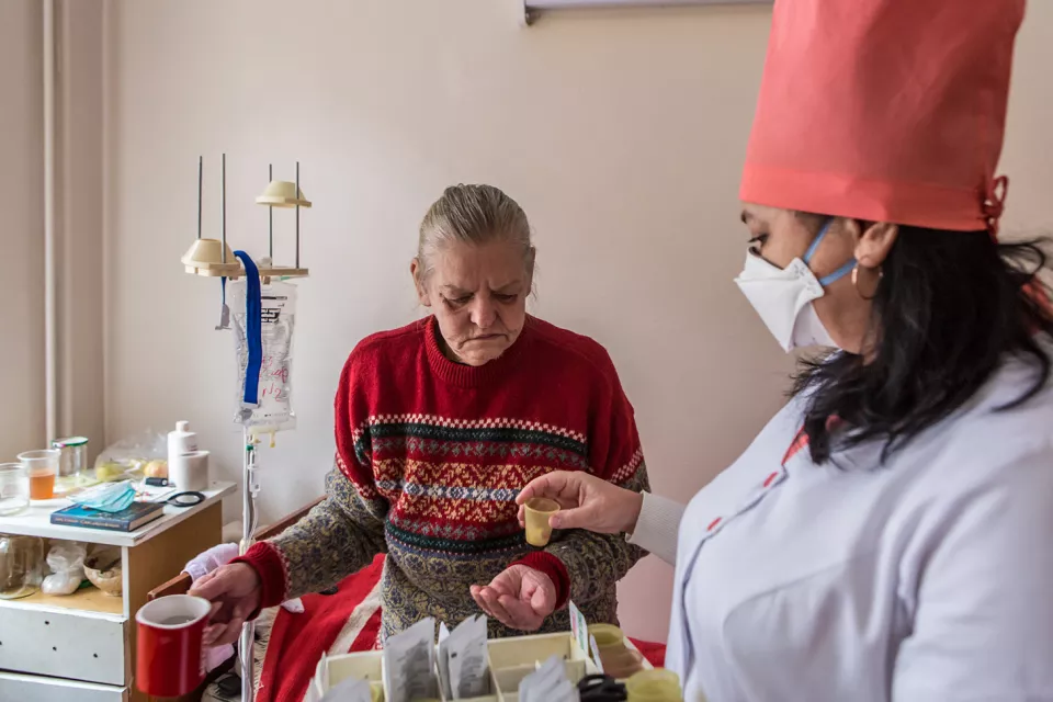 Halyna Uvarenko, 56, an MSF patient with multidrug-resistant TB (MDR-TB), receives medication from a Ministry of Health nurse in her room at the Zhytomyr Regional TB Dispensary.