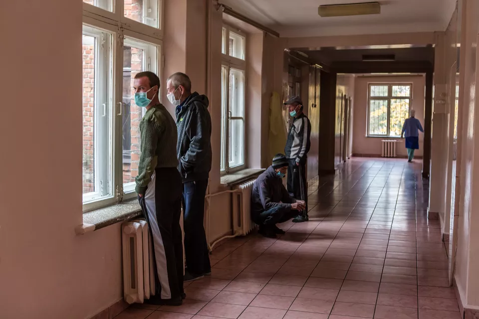 Mykola Cherkasov, 31, a patient with multidrug-resistant tuberculosis (MDR-TB) and other patients stand near the window in the corridor of the Zhytomyr Regional TB Dispensary. 