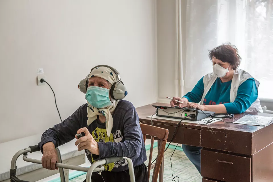 Lidiia Andriienko, 78, left, takes a hearing test conducted by Olena Markova, an MSF nurse, at the Zhytomyr Regional TB Dispensary in Zhytomyr.