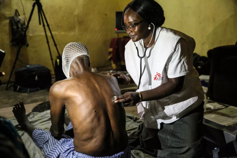 MSF doctor Djenabou Diallo examines her 76yo patient Maady Dabo in Bamako. During the consultation, which takes place at the patient’s home, Dr Djenabou Diallo checks on pain management, vital parameters, infections and any other pathologies the patient might have in addition to cancer. Maady has oral cancer (cystic adenois carcinoma in the cheek).