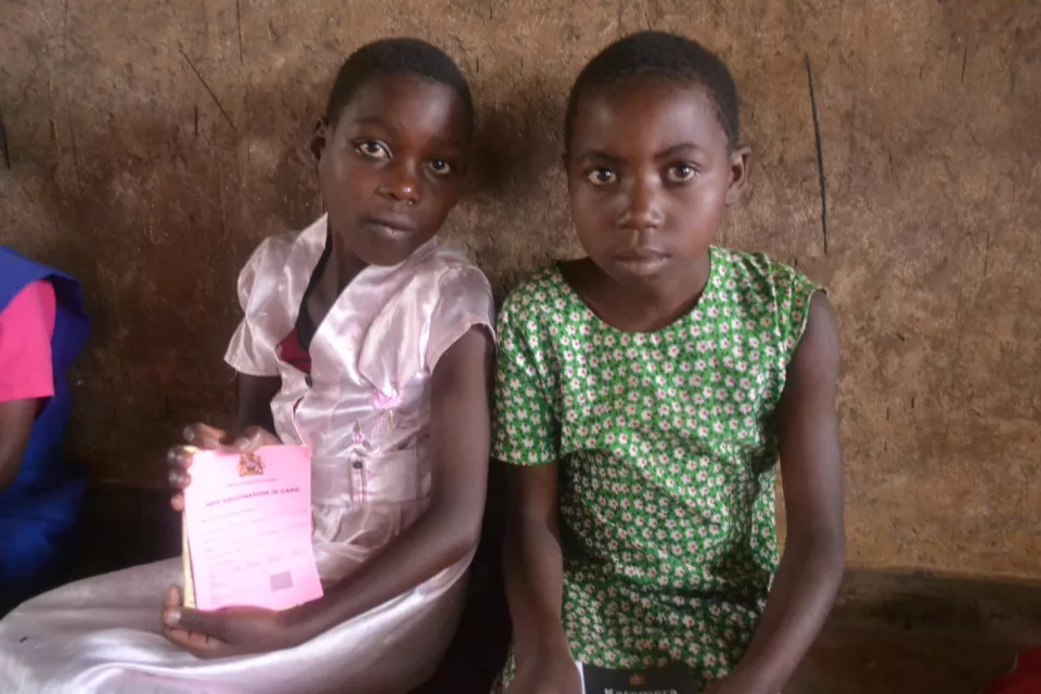 Ivy (left) and Love (right) wait to receive their vaccination.Each girl has an HPV vaccination report and ID card, used to keep track of their vaccination schedule and record consent from parents.