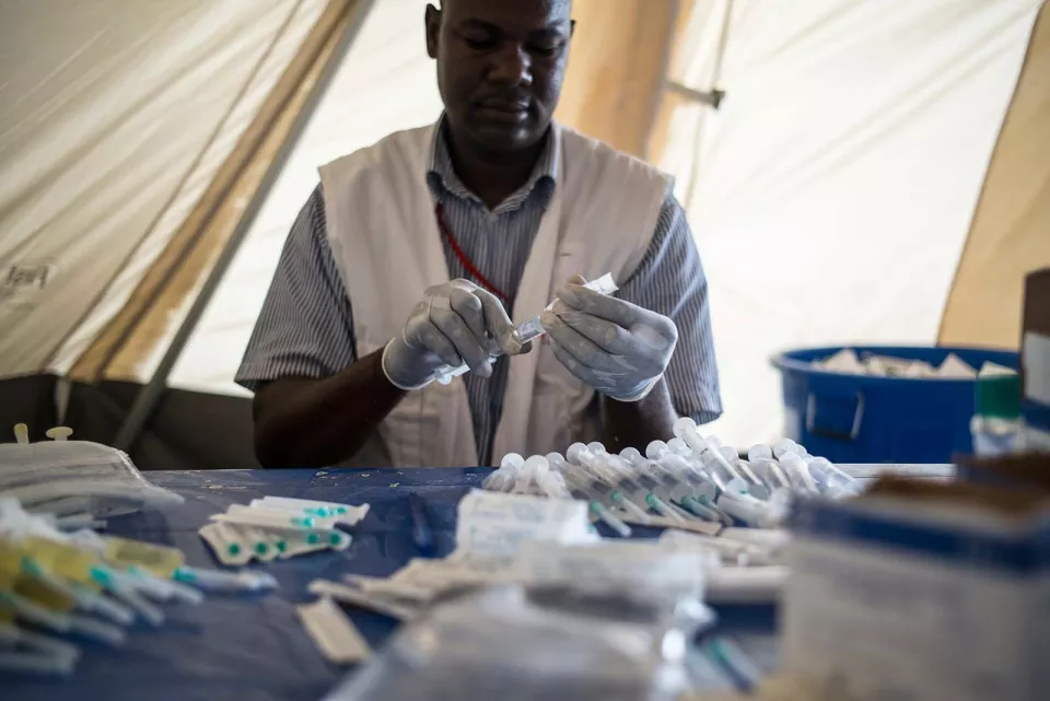 A nurse prepares a syringe with antibiotic against meningitis.