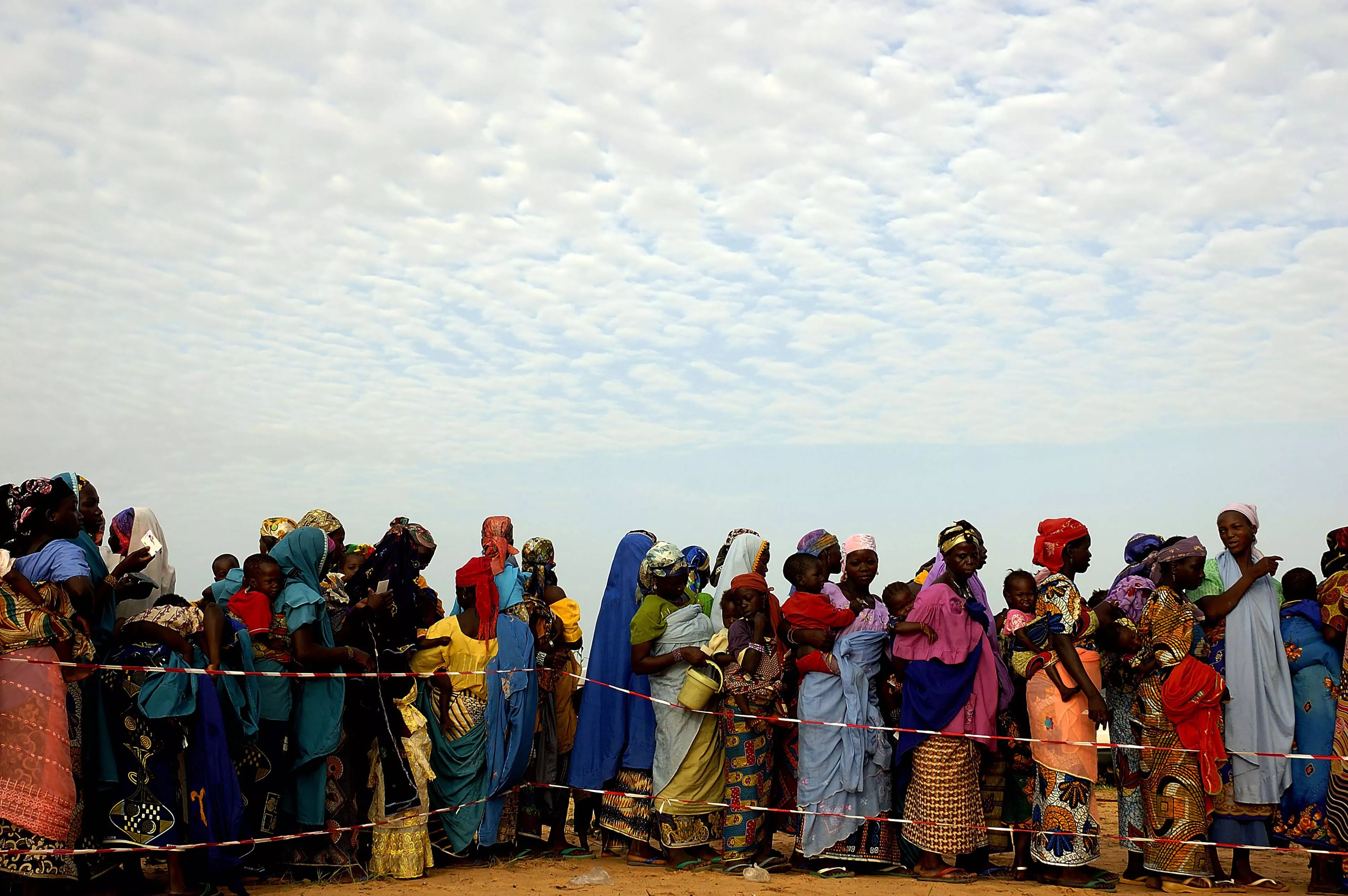 Women and their children assemble early in the morning at a ready-to-use supplemental food (RUSF) distribution site run by MSF, in Guidan Roumji, Niger, August 8, 2007.