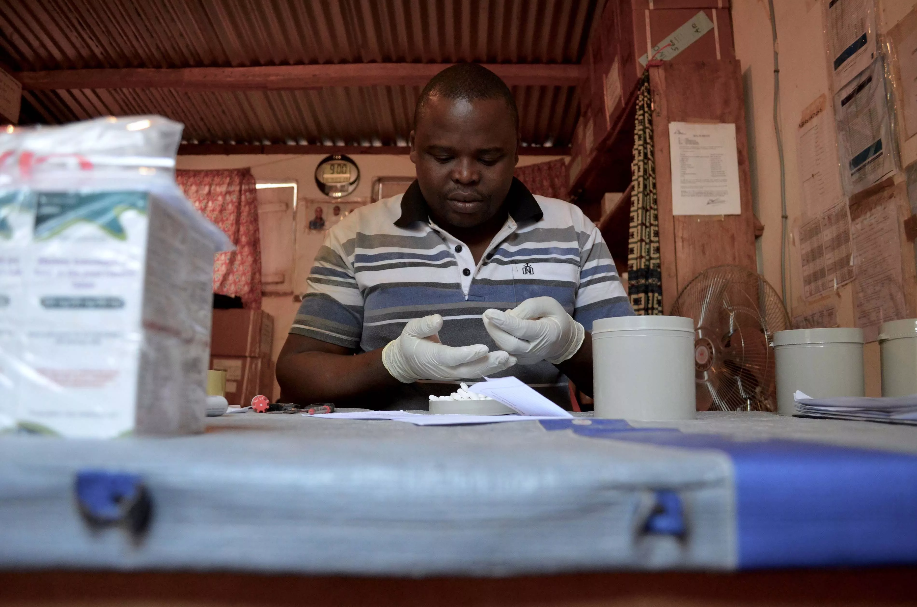 The pharmacist in Zémio, Alain, prepares Raymond’s order: ninety days’ worth of HIV medications for the 26 people in his CAG group. December 2016.  Raymond was health worker in MSF supported health center of Djema, in the south east of Central African Republic (CAR). He was also a patient in the community based HIV program MSF launched in Zemio.