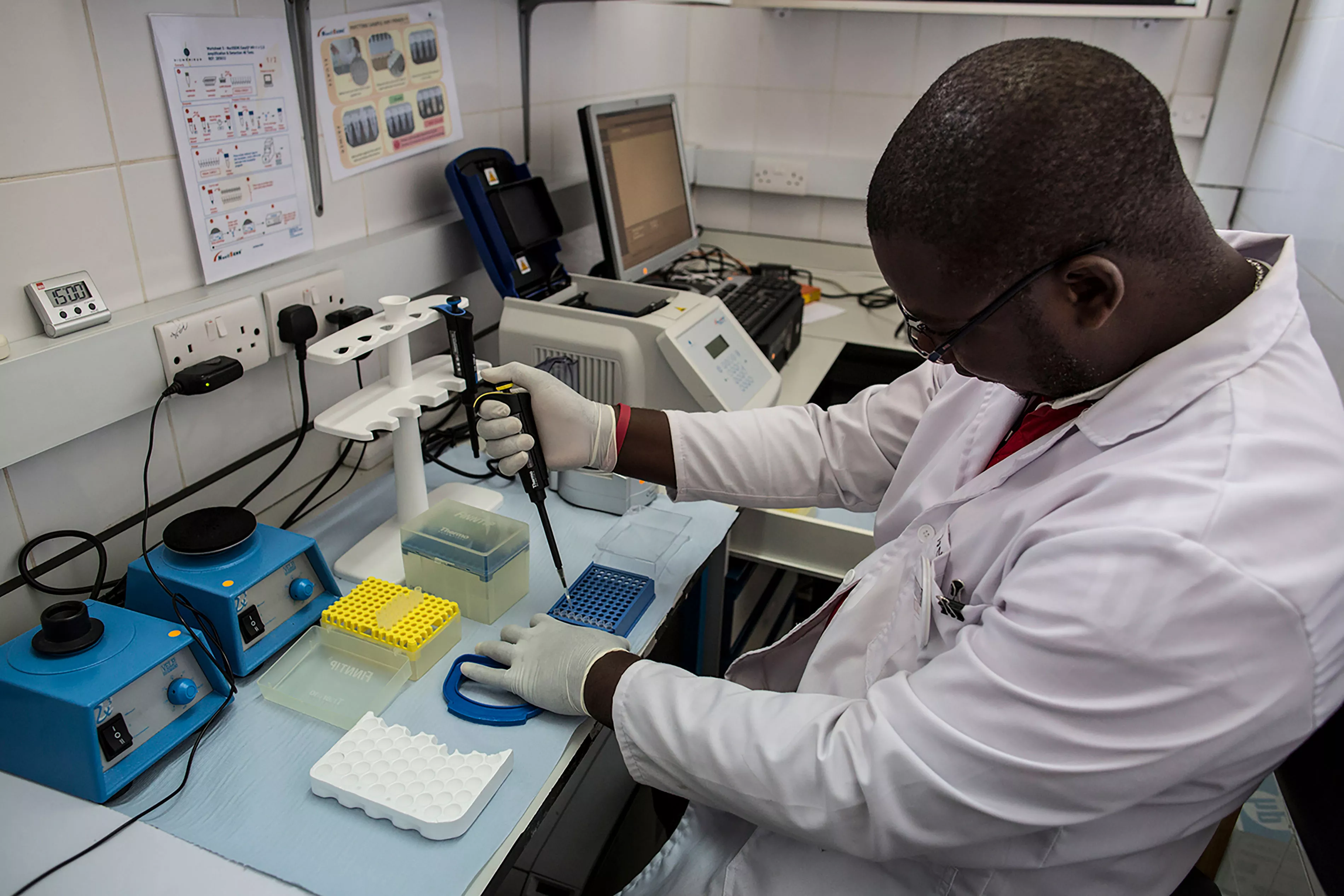 A lab technician performs a test inside the viral load room at the Thyolo District hospital for routine testing of a patient.