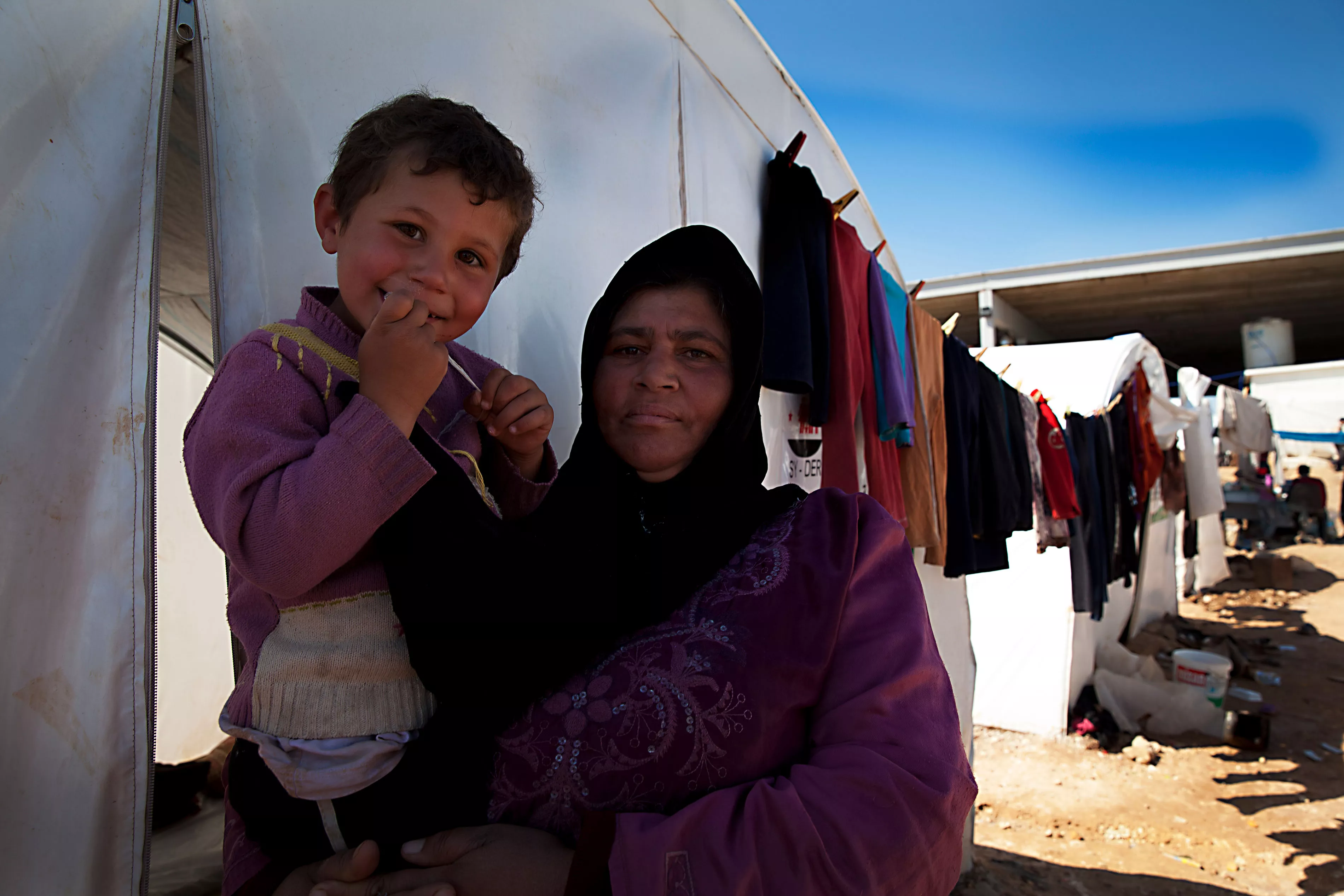 A Syrian displaced woman, Saleha Mustafa, and her young child in a transit camp next to the Turkish border.