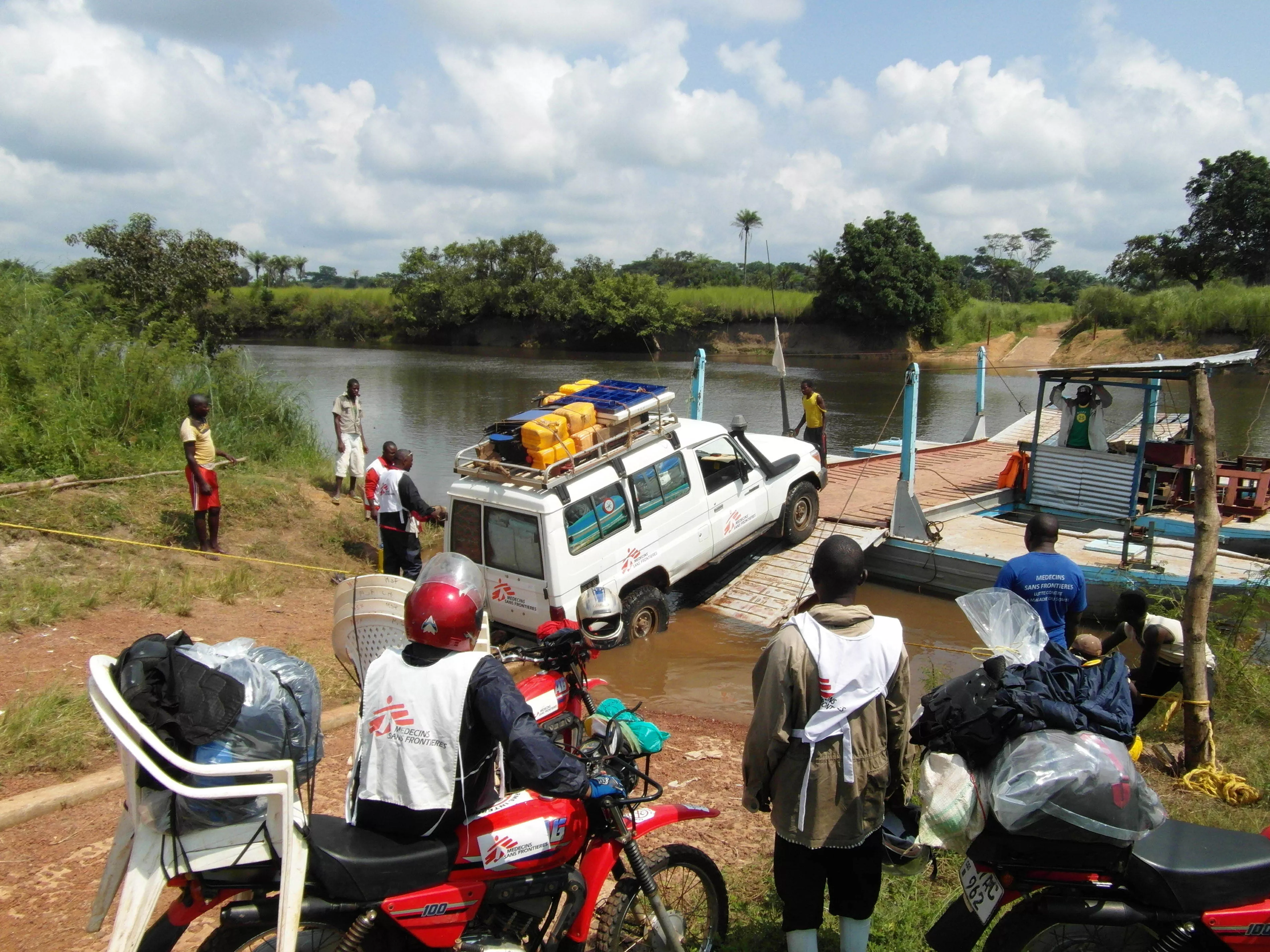 MSF mobile medical team crosses the river with cars and motorbikes to reach remote villages. 