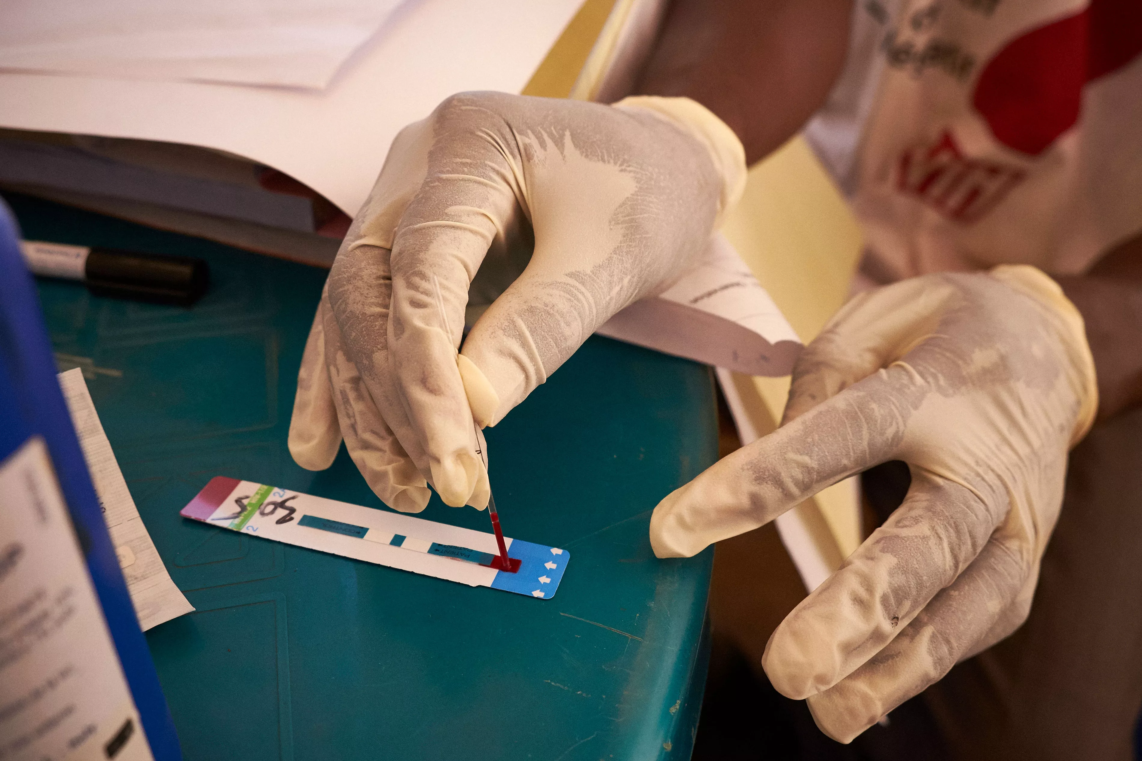 HIV activist Boubacar Camara tests a man for HIV at the Médecins Sans Frontiers (MSF) mobile clinic in the neighbourhood of Tombolia, Conakry, Guinea on March 18, 2016. 