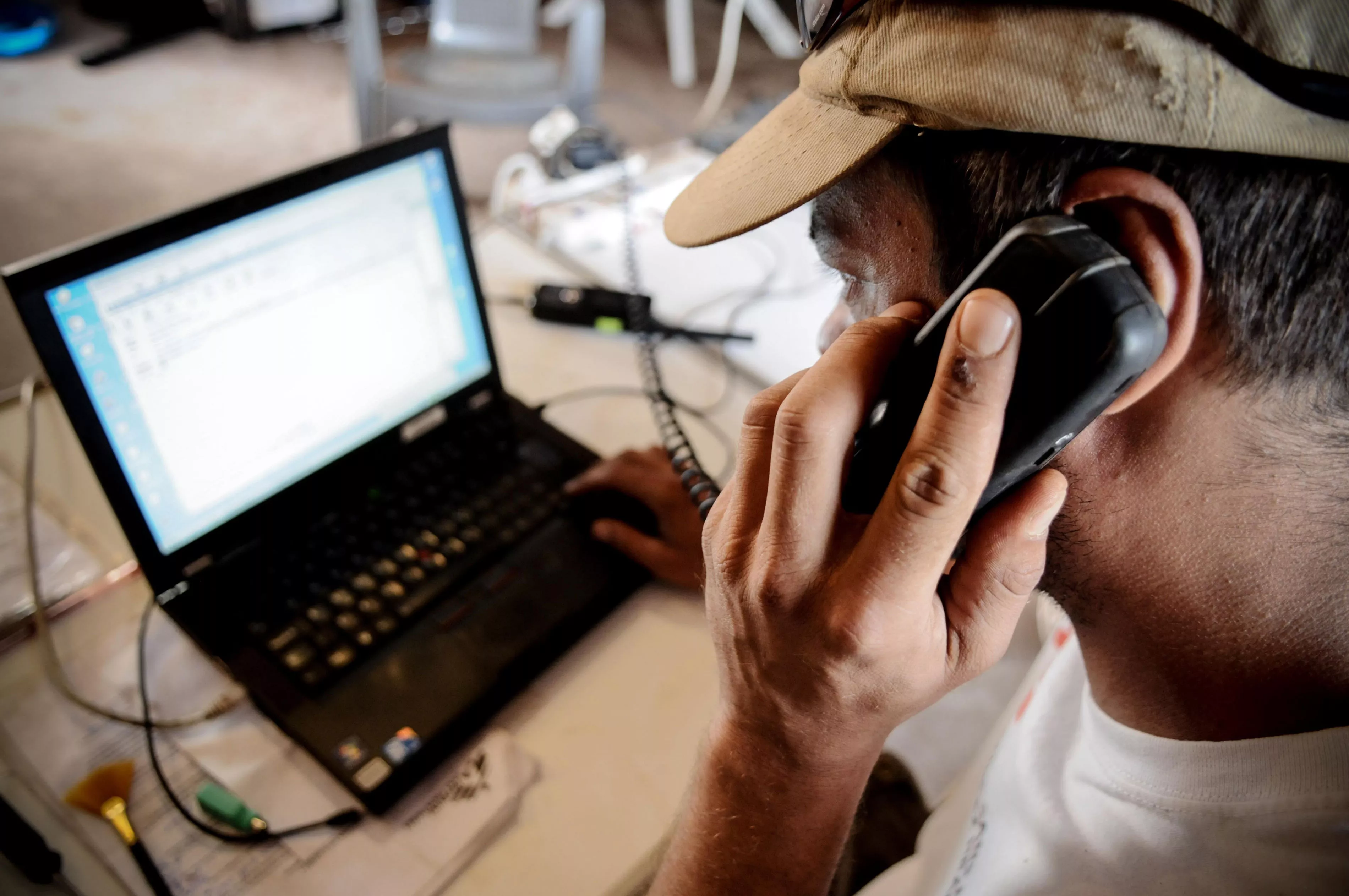 MSF employee using a phone and laptop
