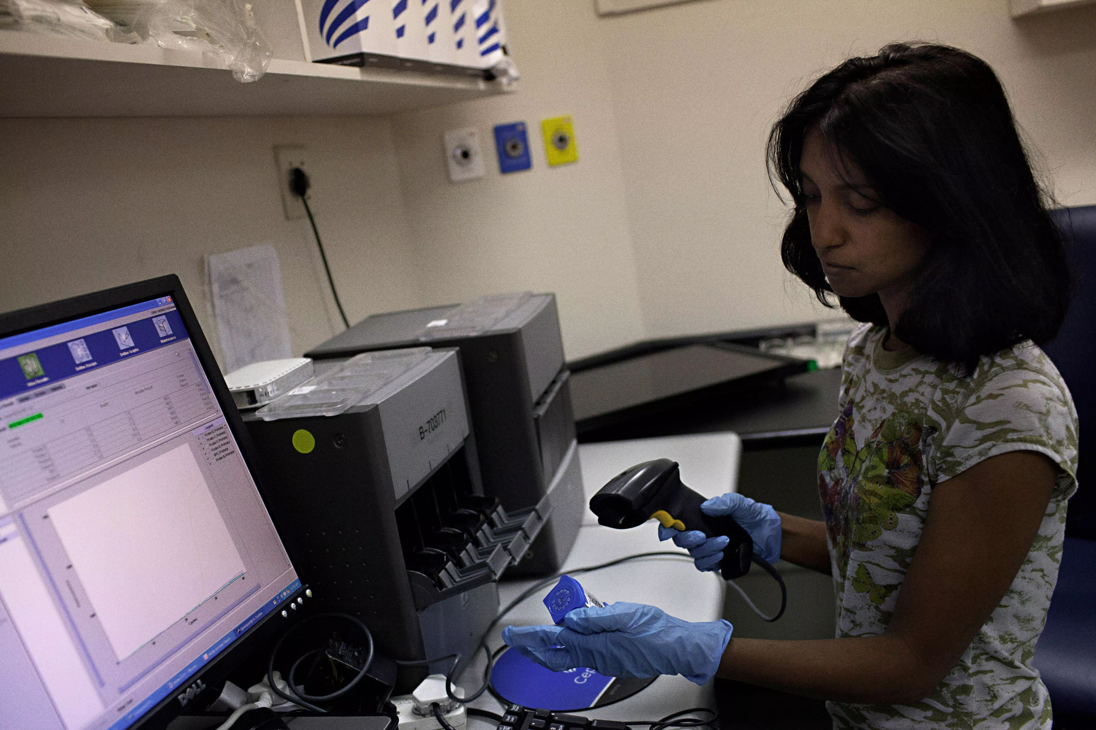 Medical officer, Neisha Mohess scans a sample of sputum for loading into the GeneXpert, an automated molecular TB diagnostic test machine.