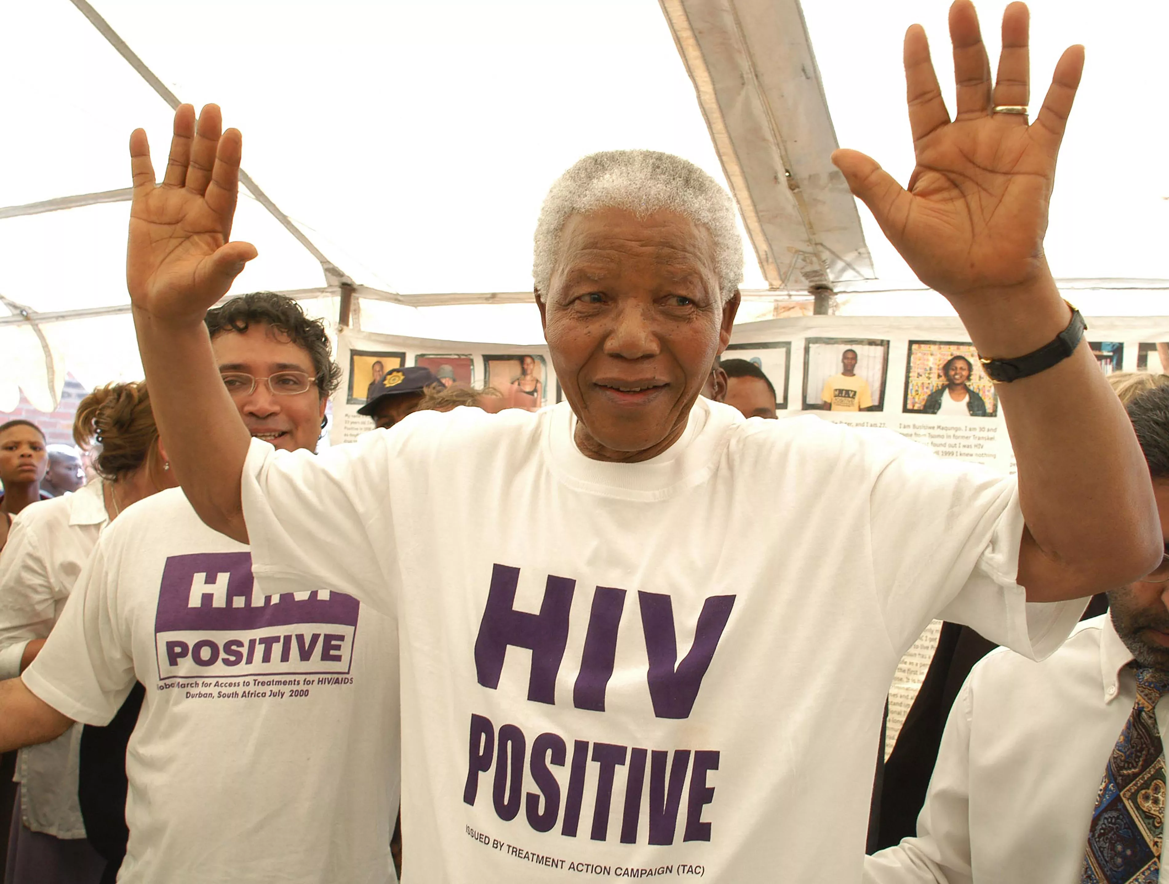 Former South African president Nelson Mandela has accepted the offer of a beneficiary of the project and has changed his shirt for an HIV-Positive T-shirt. See Zackie (Zackie Achmat of the Treatment Action Campaign, a South African NGO {TAC}) just behind.