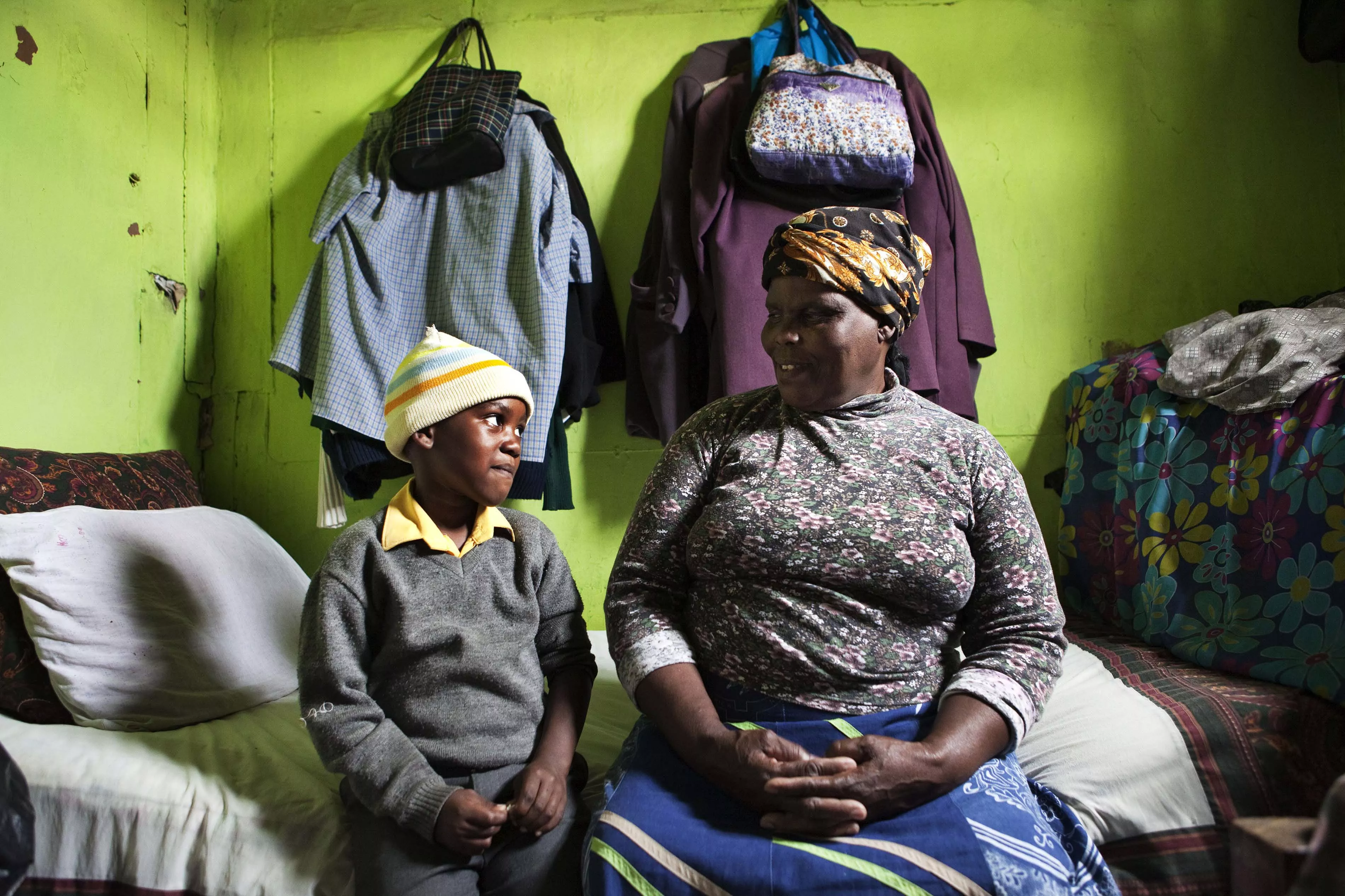 Thenjiwe Madzinga, 66, sits on with her grandson Thina Gxotelwa in the small room they share in a shack in Cape Town's Khayelitsha township, February 23, 2010. Madzinga cares for her five grandchildren, including four who were orphaned when Madzinga's own daughter died from AIDS in 2002. Some 5.5 million people live with HIV/AIDS in South Africa - more than in any other country - placing a heavy burden on a society still struggling with the legacy of Apartheid. 