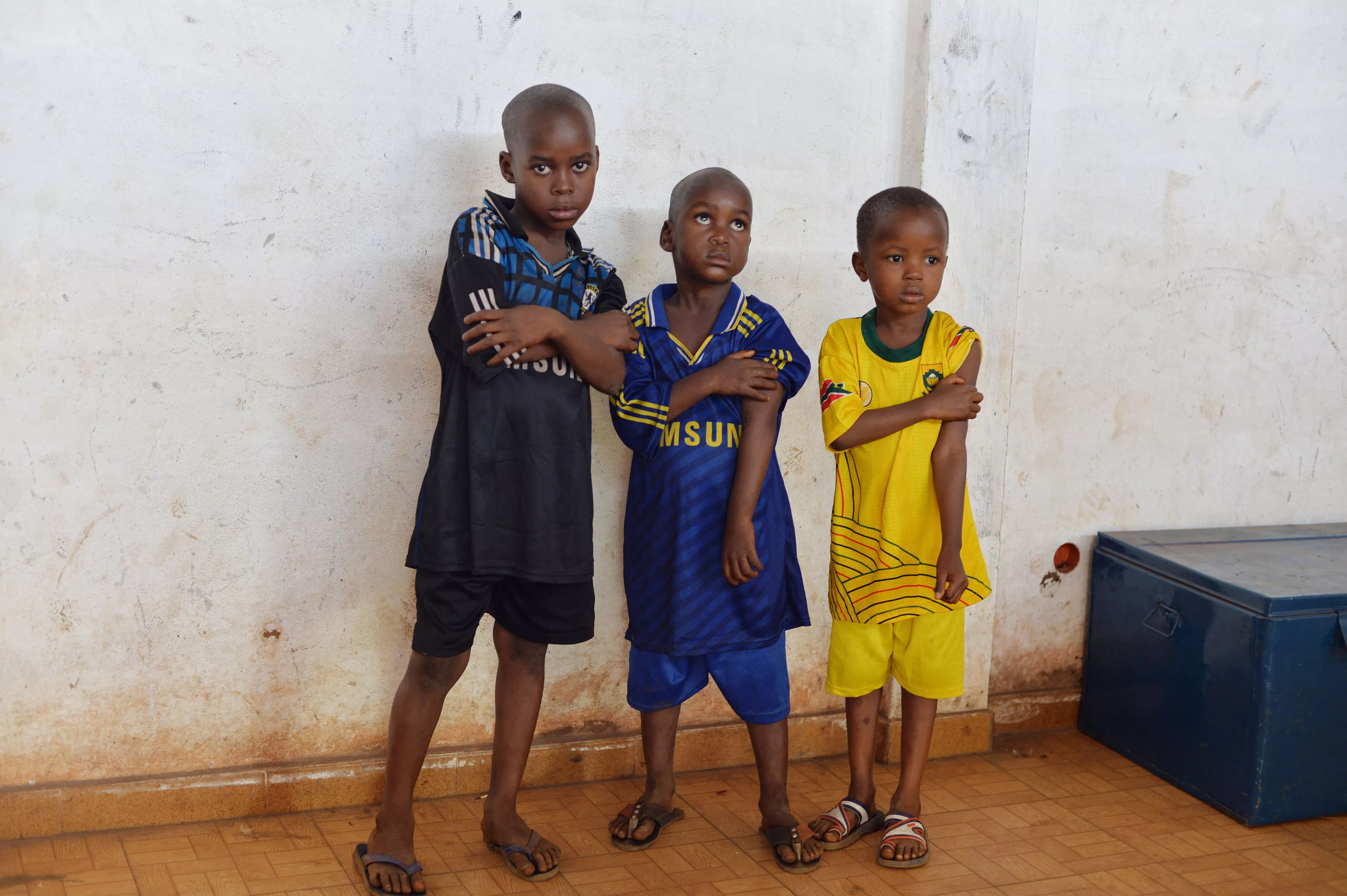 Three young boys at a vaccine clinic in Guinea