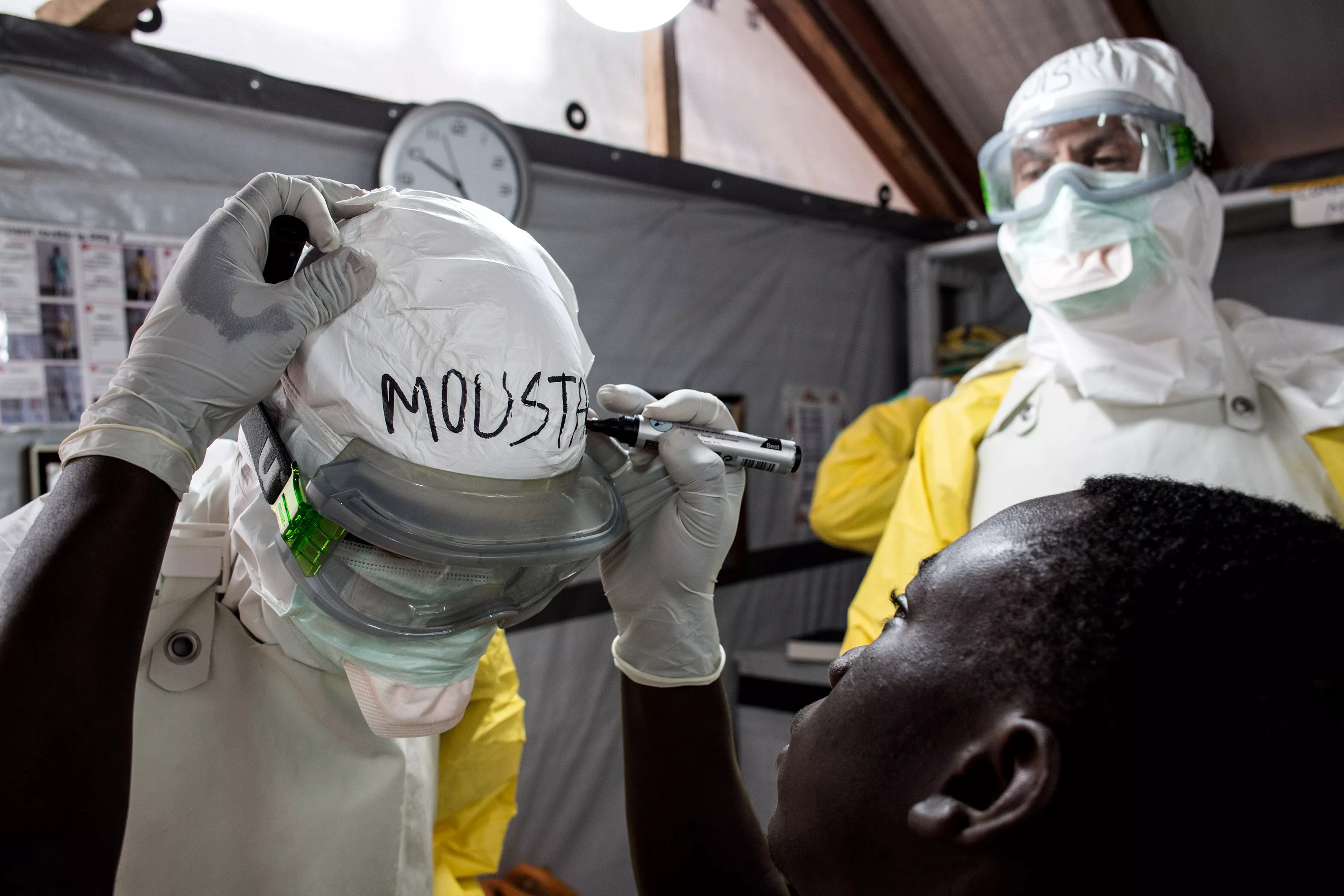 Health workers are seen writing their names on their personal protective equipment (PPE) before entering the red zone of a MSF supported Ebola Treatment Centre(ETC), where the will be checking up on patients on November 03, 2018 in Butembo.