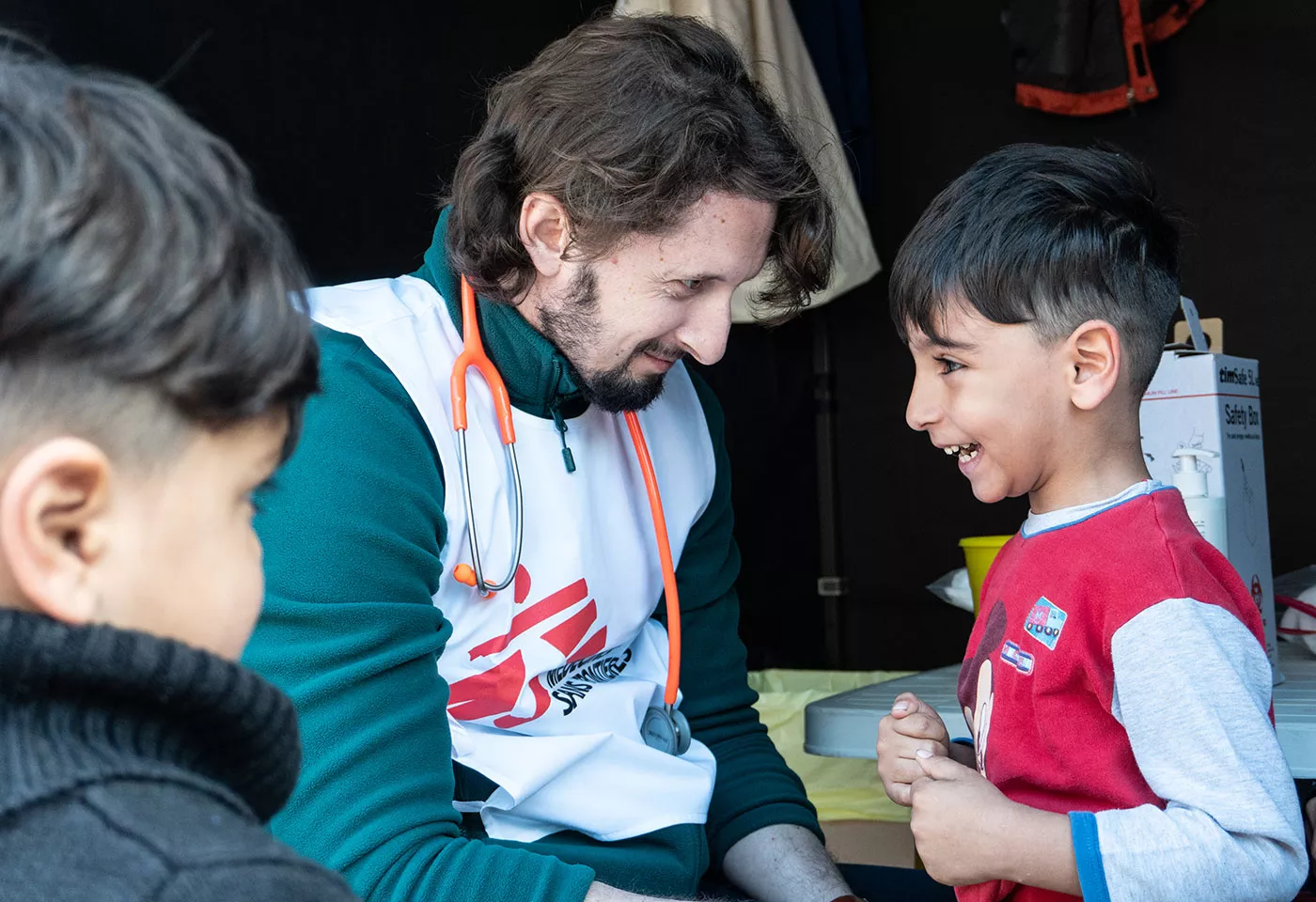 •	MSF medical doctor, Stefanos Tsallas vaccinates a child from refugee camp against pneumonia 