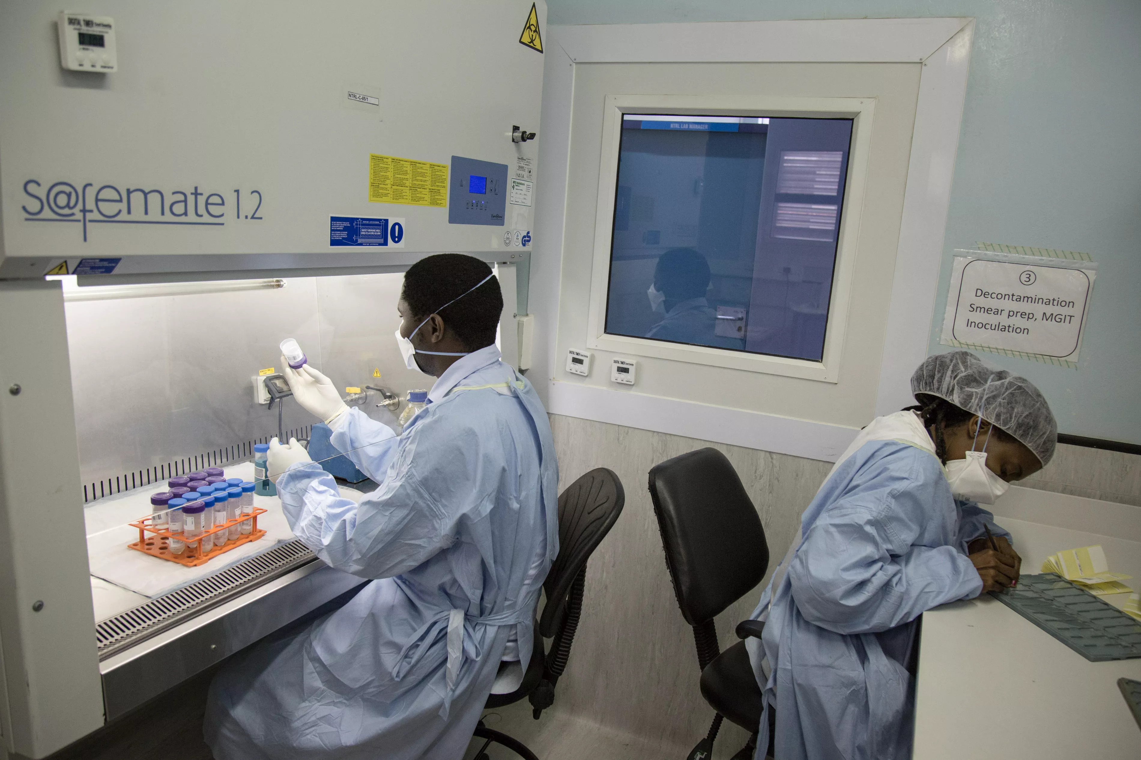Lab technologists preparing sputum samples to realize bacteria cultures. Kwanele Dlamini (left), MSF Lab Technologist, & Nobuhle Matsabula (right), MoH Microscopist. National TB Reference Laboratory , Government Hospital, Mbabane, Swaziland.