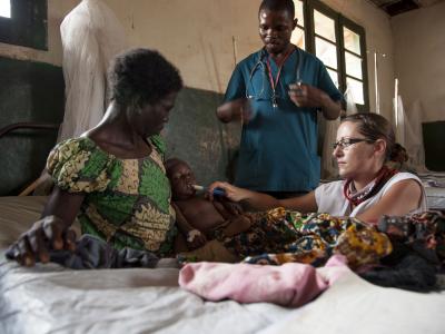 Sophie Allot, a MSF nurse, gives therapeutic milk to a child affected by measles and malnutrition inside the intensive care unit of the Titulé hospital. Malnutrition is a medical complication often associated with measles.